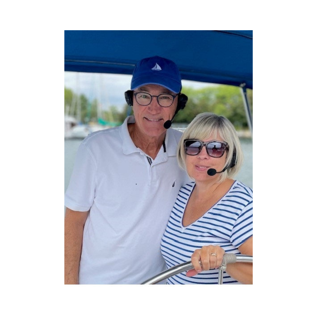 Happy couple on a boat using Bluetooth headsets for boaters , enjoying smooth communication with 2Talk Marine Marriage Savers.