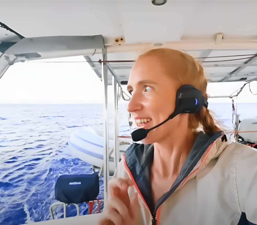 Person using Full Duplex Wireless MESH Intercom System headset on a boat with water in background.