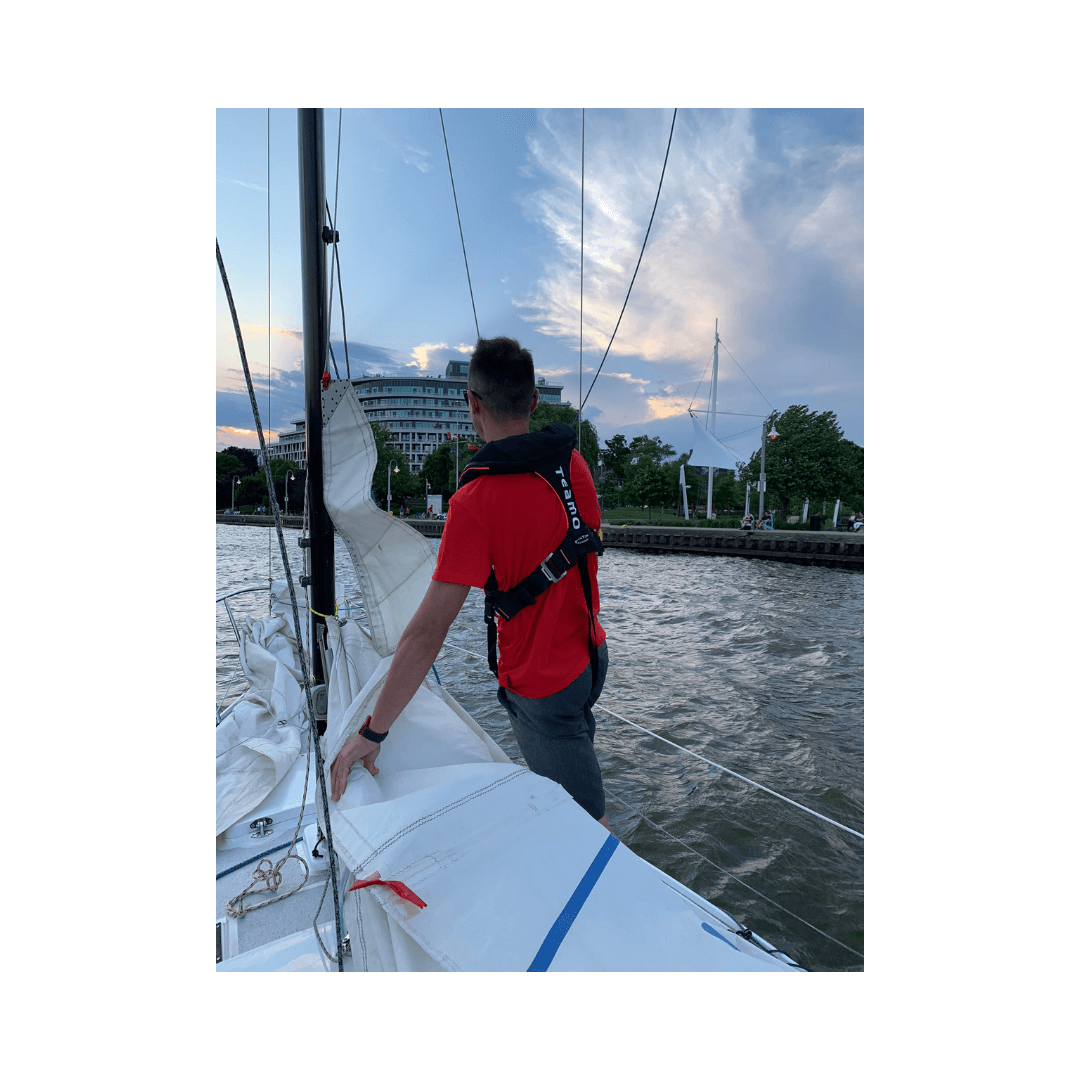 Sailor wearing TeamO Offshore PFD with BackTow Technology while sailing on a boat