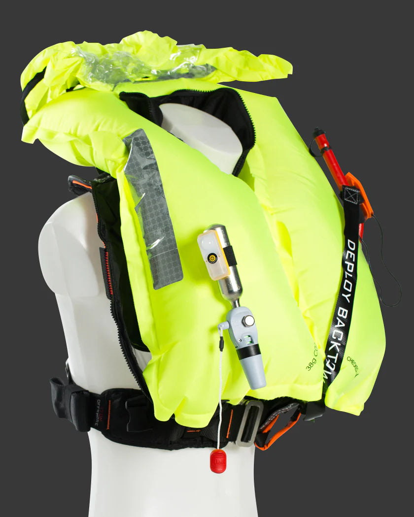 Fluorescent yellow bladder PFD or life jacket with deployment mechanism of BackTow inflated TeamO PFD with a whistle and self inflate and reflective  strips on a mannequin against a dark background