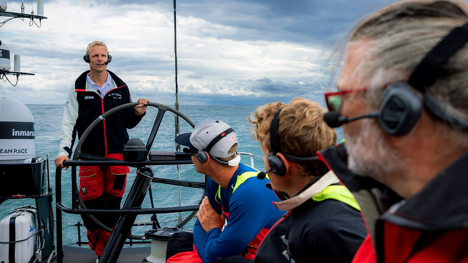Sailboat crew using Sena NautiTalk Bosun marine communication headsets underway during a crew update