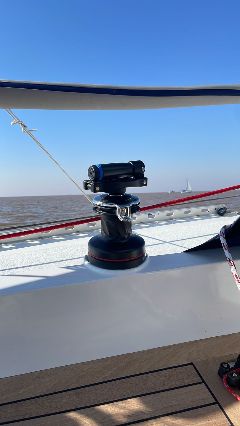 Folding winch handle EasySea shown mounted on a sailboat with blue sky and water in the background.