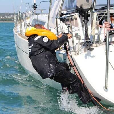Person using a 9 step emergency boat ladder to reboard a dinghy safely on the water.